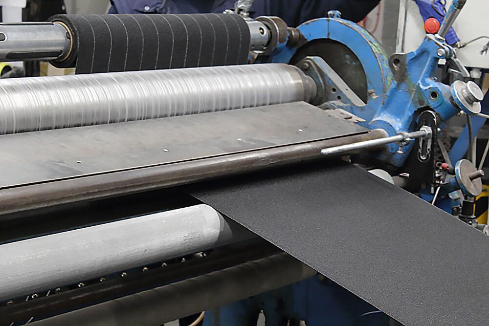 Black Anti-Slip Material being Cut on a Crush Cutter into Rolls of Non Slip Tape